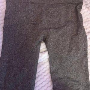 Grå leggings i polyamid och polyester - Säljer ett par grå leggings i storlek L. De är tillverkade av 54% polyamid, 34% polyester och 12% elastan, vilket gör dem superstretchiga och bekväma. Perfekta för träning eller en chill dag hemma. 🖤