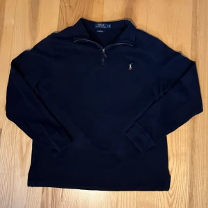Snygg marinblå ralph lauren zip - Snygg marinblå ralph 1/4 zip i nyskick. Inte alls använd mycket. True to size passar M/L. Säljs till sjukt bra pris då den kostar 2200kr ny. Ställ gärna frågor..