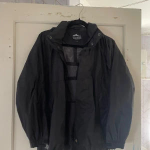 Svart jacka från True North - Säljer en svart jacka från True North. Den har en huva och dragkedja framtill. Perfekt för kyligare dagar och har en stilren design. Jackan är i bra skick och passar till både vardag och friluftsliv.