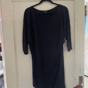 Svart klänning från J&n - Säljer en elegant svart klänning från J&n. Den har en enkel och stilren design med trekvartsärmar. Perfekt för både vardag och festliga tillfällen. Klänningen är i storlek 48 och har en bekväm passform.