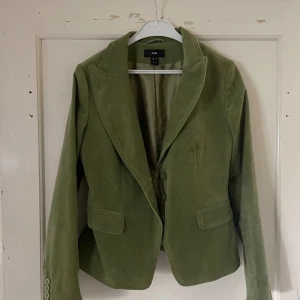 Olivgrön kavaj från H&M - Säljer en snygg olivgrön kavaj från H&M i storlek 38. Den har en klassisk design med två knappar fram och fickor. Perfekt för både vardag och fest! 💚