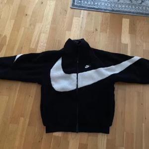 Nike jacka swoosh 2 way - Storlek S men skulle säga att den passar S-M. Kan användas på olika håll se bilderna. Nyskick använd ett par gånger men sedan har den bara legat i garderoben så skulle säga nyskick.