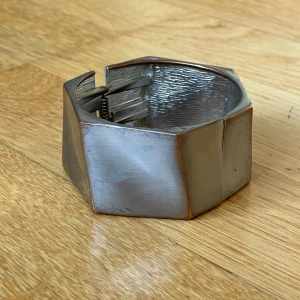 Silver Manschettarmband  - Chunky, metallfärgat/silver manschettarmband. Har ett gångjärn så det går att öpnna och stänga för när man ska ta på/av det. 