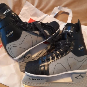 Svart och grå skridskor från TecnoPro - Säljer ett par stilrena skridskor från TecnoPro i svart och grått. De har snörning och en robust design med märket Colorado på sidan. Perfekta för vinterns isäventyr.