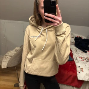 Beige hoodie från Champion - Säljer en snygg beige hoodie från Champion med logga på bröstet. OANVÄND!!🫶🏻