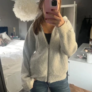 Grå stickad kofta med dragkedja - Mysig grå stickad kofta med dragkedja framtill. 