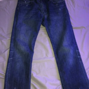 Blå jeans från Emporio Armani - Snygga blå jeans från Emporio Armani med klassisk femficksdesign och logotypdetalj på fickan. Perfekta för en stilren look.