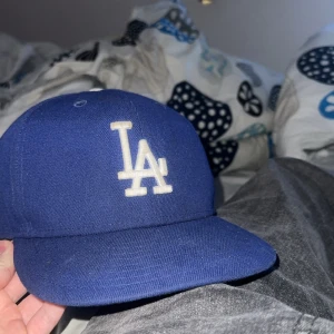 La keps - Säljer en blå  la keps, fint skick använt kanske någon månad. storlek 7 (55,8 cm)