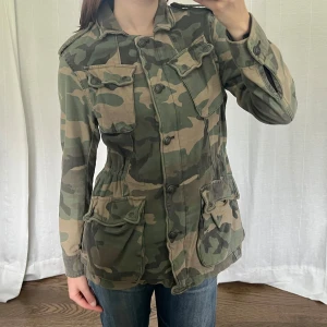 Free People militärjacka - Militärjacka från Free People i modellen ”Not Your Brother's Jacket”. Man kan spänna åt vid midjan. Storlek S, jag har storlek M och den passar mig och den kan nog passa XS också beroende på hur man vill att den sitter