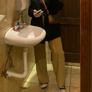 Beige kostymbyxor från Bershka - Snygga beige kostymbyxor från Bershka i storlek 38. De är högmidjade med en klassisk rak passform och har en stilren design med knappdetalj. 