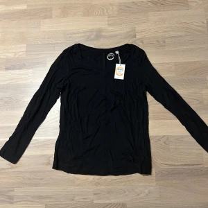 Svart långärmad tröja - Säljer en stilren svart långärmad tröja i mjukt material. Perfekt för kyligare dagar och enkel att matcha med olika outfits. Oanvänd (med prislapp). Är i storlek 8 (36). Inköpspris; 10£. 