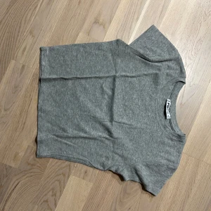 Grå t-shirt  - Säljer en stilren grå t-shirt från FB sisters. . Den har en klassisk rund hals och korta ärmar, perfekt för en avslappnad look. Materialet känns mjukt och bekvämt mot huden.