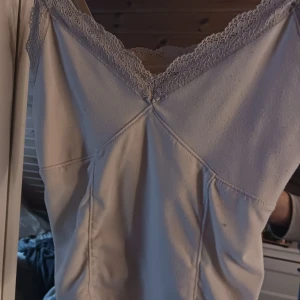 Vitt linne med spetsdetaljer - Säljer ett vitt linne från hm. Syns att det är använt och därav priset💗