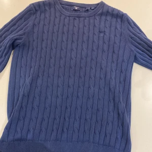 Blå kabelstickad tröja från Gant - Säljer en snygg blå kabelstickad tröja från Gant. Säljer för att den är för liten, om man vill ha bild med den på så går det bra 