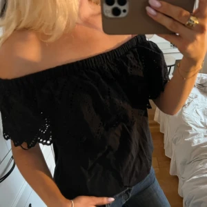 Svart offshoulder topp - ASSNYGG svart offshoulder topp med spetsdetalj. Toppen har en luftig passform och passar perfekt till festliga tillfällen😍🥰
