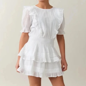 Vit kort klänning  - Charmig vit klänning med volanger och korta ärmar. Resor i midjan. Perfekt till studenten eller sommaren. Passar mig som är storlek 34. Använd 1 gång 🤩 egna bilder privat 