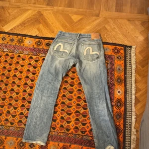 Evisu jeans 32/32 - Snygga jeans från evisu. Storlek 32/32. Skick: se bilder, små hål osv, men fortfarande acceptabelt. Jag lyssnar på bud :)