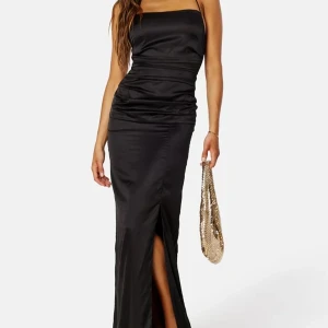 Svart elegant långklänning med slits - Säljer min balklänning, endast använd en gång! En elegant långklänning från Bubbleroom Occasion med smala axelband och öppen rygg. Klänningen har slits, drapering runt midjan och knytdetalj i ryggen som går att justera 🫶🏼