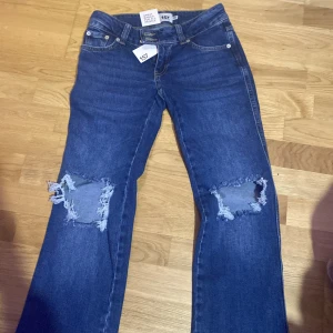 Blå bootcut jeans med slitningar - Snygga blå bootcut jeans från Paris Core i storlek XS. Köpte i fel storlek och hittar inte kvittot för att returnera:/. Annars är dem skit snygga och trendiga, köpta idag för 400. Alltså är dem helt nya.