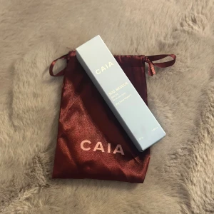 SOS Rescue Balm från CAIA - SOS Rescue Balm från CAIA, perfekt för alla hudtyper. Innehåller sheasmör och vitamin E för extra vård och skydd. Kommer i en elegant ljusblå förpackning med en röd påse för förvaring.