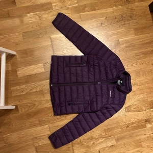 Lila dunjacka från Cross Sportswear - Säljer en snygg lila jacka från Cross Sportswear. Perfekt som mellanlager. Jackan har en dragkedja framtill och är långärmad. Perfekt för kyligare dagar med sin quiltade design.