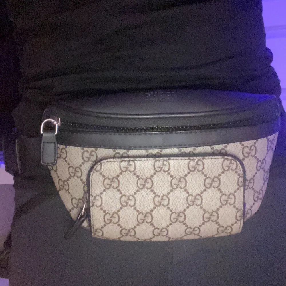 Snygg magväska från Gucci med det klassiska GG-mönstret. Väskan har en justerbar rem och en dragkedja för säker förvaring. Perfekt för att bära med sig det viktigaste på ett stilfullt sätt.. Laukut & Käsilaukut.