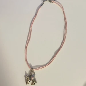Pegasus häst halsband med rosa stenar  - Barn halsband på ca 35cm + 4cm. Hänget går att ta av vilket är bra då halsbandet är lite gammalt och smutsigt. Kanske går att tvätta men sitter tajt på mig som vuxen, så är nog att föredra längre kedja ändå! Hänget har inga avvikelser iaf 💕
