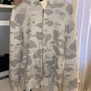 Säljer min vita bape zipup hoodie då den inte kommer till användning. Jätte skön och snygg. Storlek XL men sitter som en M. Lyser i mörker! Inte äkta. Skriv vid frågor eller fler bilder.