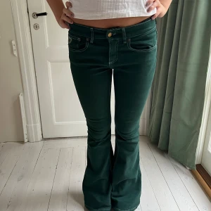 Gröna Lågmidjade jeans  - Så snygga unika gröna jeans från märket LOIS, midja 77 cm innerbennet: 82 cm, hon på bilden har vanligtvis 27/28 i jeans och är 173 cm
