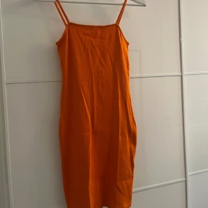 Orange klänning  - Använd ett fåtal gånger därav den avklippta lappen, annars är skicket så gott som nytt 