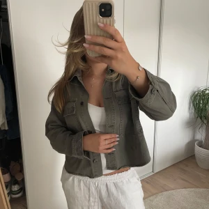 Militärgrön jeansjacka/ trench - Militärgrön jeansjacka/ trenchcoat med broderidetaljer på fickor, ärmar och krage. Perfekt på sommaren eller nu i tidig höst!🍂Inget tecken på slitage