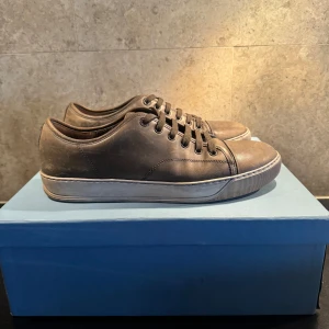 Mörk grön snor från Lanvin - Snygga bruna sneakers från Lanvin med snörning och en stilren design. Skorna har en rund tå och är tillverkade i skinn, de är storlek 44