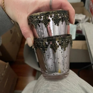 Lila dekorativa glas - Två lila glas med antik stil och dekorativa metallkanter. Glasen har en fläckig design som ger en vintagekänsla. Perfekta som ljuslyktor eller för dekoration i hemmet.