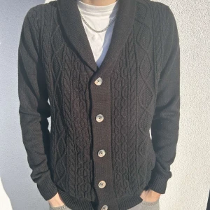 Svart Stickad Kofta från Threadbear - V-ringad Stickad Kofta med knappar, i färgen svart, tröjan är från märket ”threadbare” och i storleken M. Skicket är mycket bra! för referens har modellen storlek M/L i vanliga fall. 