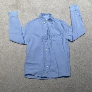 Ljusblå skjorta från Zara - Säljer en stilren ljusblå skjorta från Zara. Skjortan har långa ärmar och knappar framtill samt vid ärmsluten. Perfekt för en klassisk look. Storlek är XS men passar även S. Pris går att diskutera.