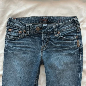 Blå jeans med olika detaljer - Supersnygga blå jeans från Silver Jeans💝💝 De har en klassisk femficksdesign och en knappgylf⭐️Storleken är W26, jag är 172cm