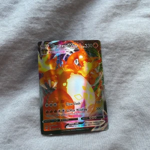Charizard VMAX Pokémonkort - Säljer ett Charizard VMAX Pokémonkort med 330 HP. Kortet har en färgglad design med Charizard i fokus och inkluderar attacker som Claw Slash och G-Max Wildfire. Perfekt för samlare eller Pokémon-entusiaster! Obs igen frakt !