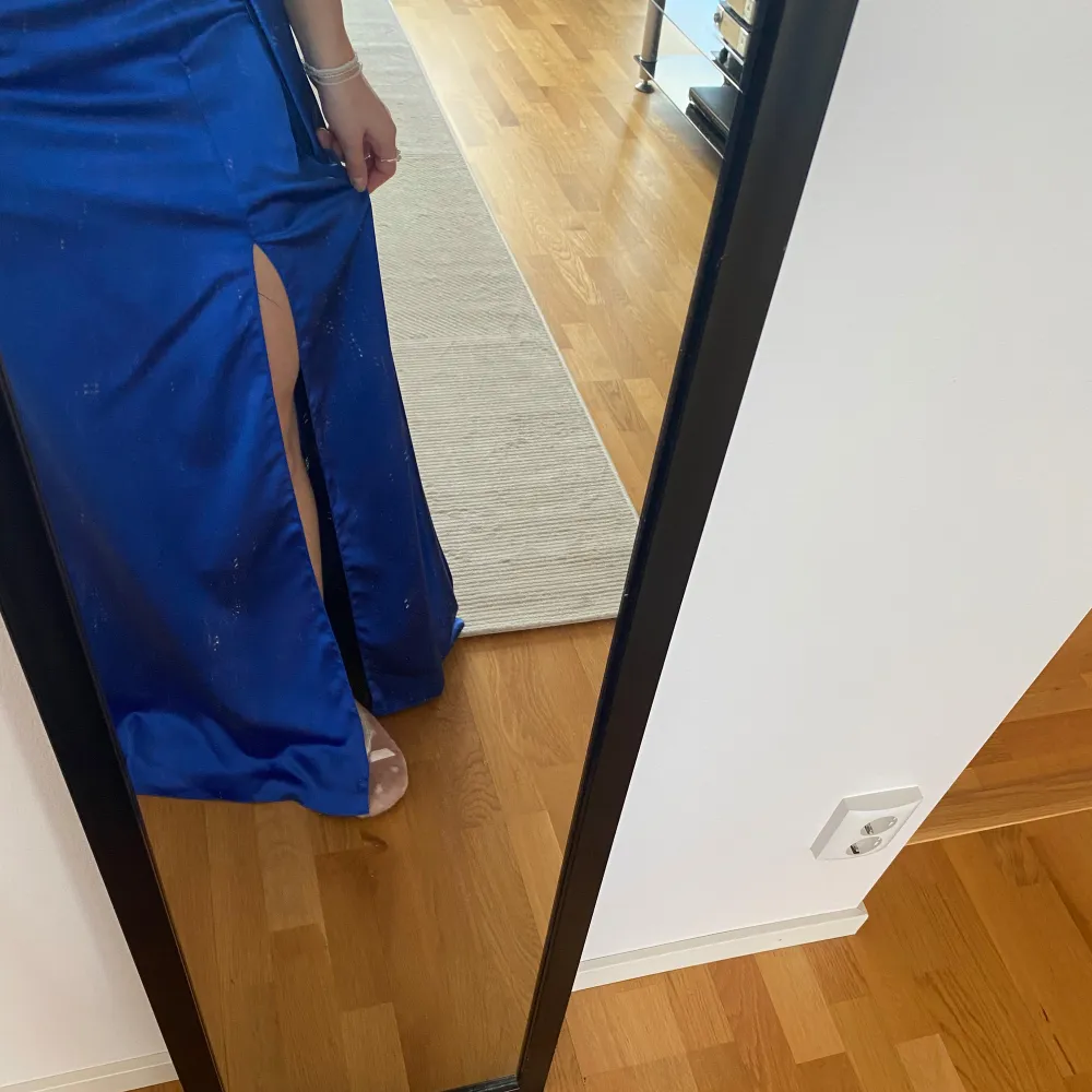 Elegant blå långklänning i satin i gott skick. Man kan ha det tunna bandet på olika sätt som man ser på bilderna. Köpt för ca 3000kr💓(säljer även mina systrars balklänningar) Pris går att diskutera . Mekot.