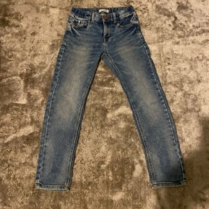 Blå jeans och beige chinos för barn strl 134 - Säljer ett par klassiska blå jeans och ett par beige chinos för barn. Lindex och Hampton Republic knappt använd 
