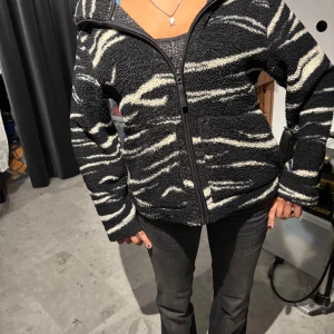 Svart och vit fleecejacka med zebramönster - Säljer en mysig svart och vit fleecejacka med zebramönster som inte längre säljs! Jättebra till kyligare somrar❤️💘💕