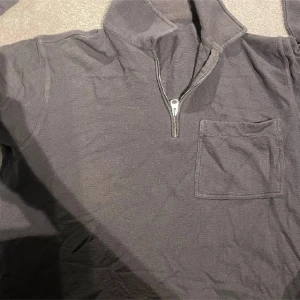 Grå tröja med dragkedja - Säljer en grå tröja med dragkedja och bröstficka från arket .Perfekt för en avslappnad stil. Tröjan har långa ärmar och en hög krage.