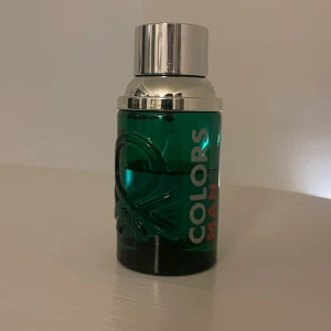 Colors Man Parfym från Benetton - Snygg parfymflaska i grönt glas med silverfärgad kork från Benetton. Flaskan har en modern design med texten 'Colors Man' i vitt och rött. Perfekt för den stilmedvetna mannen. Box tillkommer inte. Lite mer än hälften kvar.