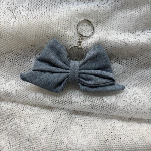 Blågrå rosett i denimtyg - Söt blågrå rosett i denimtyg. Perfekt som en stilren accessoar för att hålla koll på dina nycklar. Rosetten ger en elegant touch och är lätt att fästa på väskor eller nyckelknippor. (Vi erbjuder att möta upp i Stockholms innerstad, Huddinge, Tyresö och Lidingö) 
