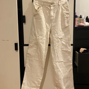 Vita cargopants - Säljer ett par vita/krämvit cargopants i bra skick. De har en loose passform och är perfekta för en avslappnad stil. Byxorna har flera praktiska fickor och är gjorda i ett slitstarkt material. Perfekta för vardag. De är skrynkliga eftersom de länge legat i garderoben men med lite strykning sitter de som en smäck!