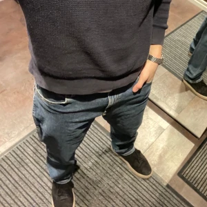 Wrangler Texas Jeans - Säljer ett par Wrangler Texas jeans i autentisk straight fit. De är i en klassisk blå färg och har en normal passform. Perfekta för vardagsbruk och kan enkelt matchas med olika stilar. Jeansen är i bra skick och utan defekter, hör av er vid minsta fundering! (Passar mig som är 185 cm)