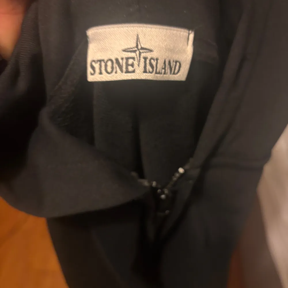 Säljer en svart hoodie från Stone Island i mycket bra skick. Den har en dragkedja framtill och en klassisk huva. Perfekt för höst och vår, med en stilren look som passar med många feta outfits. . Hoodies.