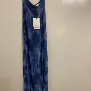 Blå axelbandslös klänning från Pull&Bear - Snygg blå axelbandslös klänning från Pull&Bear i ett coolt mönster.