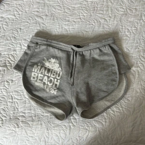 Shorts - Gråa shorts med tryck ”Malibu beach”. 