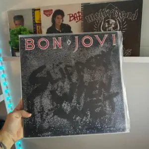 Säljer ett klassiskt Bon Jovi-album, 'Slippery When Wet'. Omslaget är svart med bandets namn i rött och albumtiteln i grått. Perfekt för rockälskare och vinylsamlare! 🎸