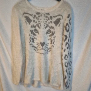 Tröja - Vit stickad tröja med leopardmotiv som är lite lurvig. Storlek 158/164 från HM. Mycket fint skick.